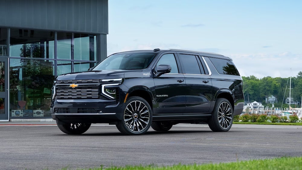 A black 2026 Chevrolet Suburban SUV parked at a marina