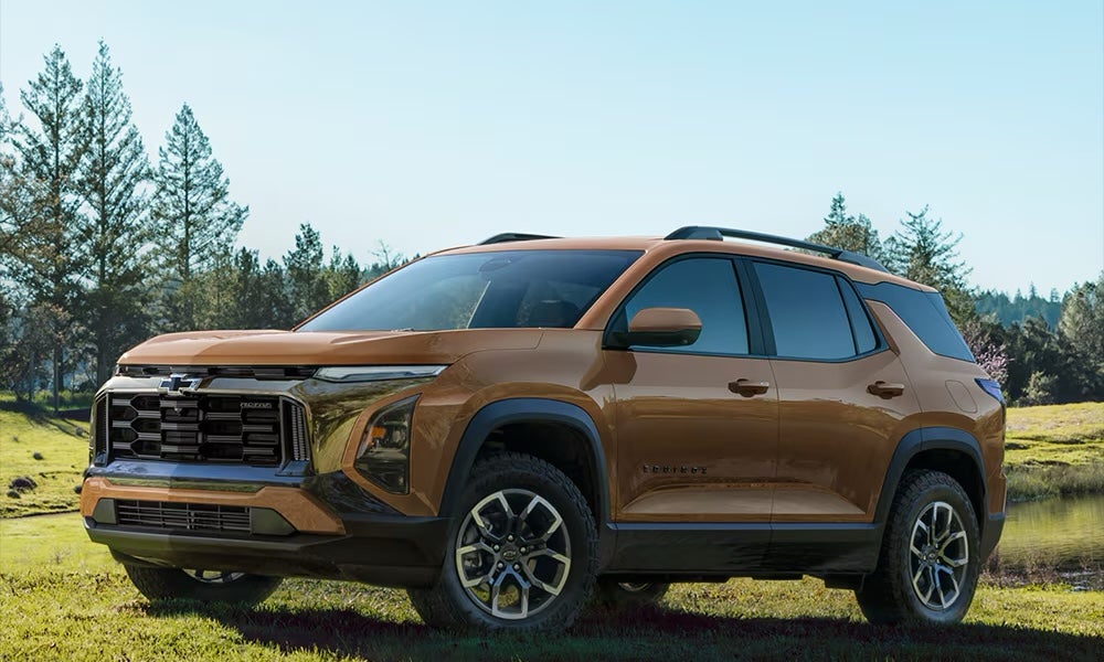 A brown 2027 Chevrolet Equinox SUV parked in a field