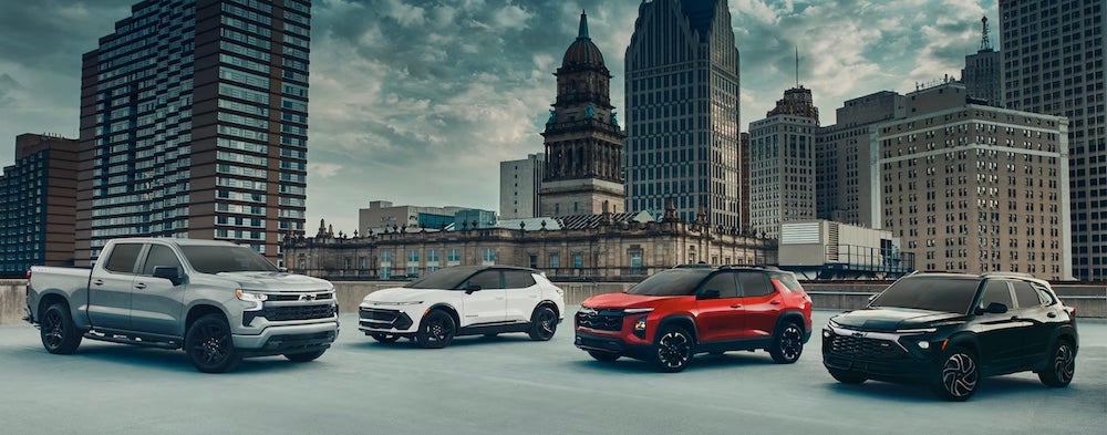 Four Chevrolet vehicles parked on a rooftop with a city skyline behind them
